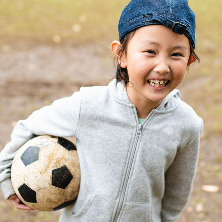 Girl outside in autumn with soccer ball