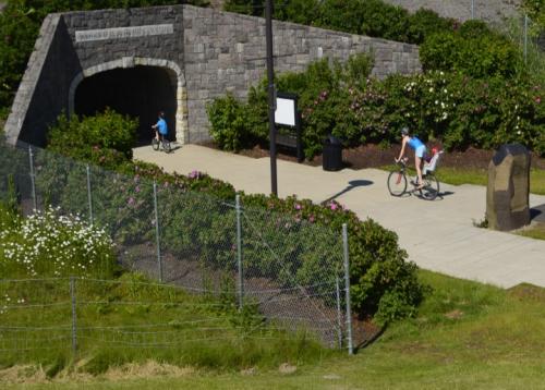 Adult and children bicycling toward a pedestrian tunnel