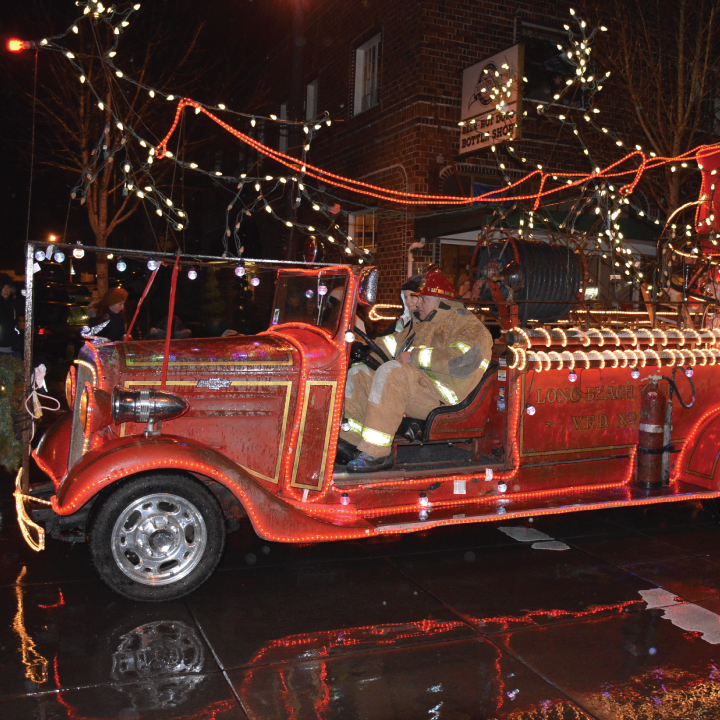 Vintage fire truck lit with Christmas lights at night