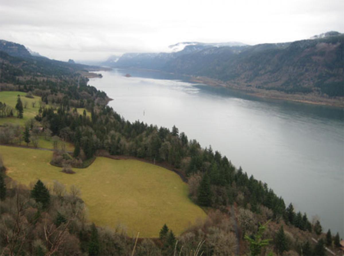River in a wide valley with hills, mountains, and trees on either side